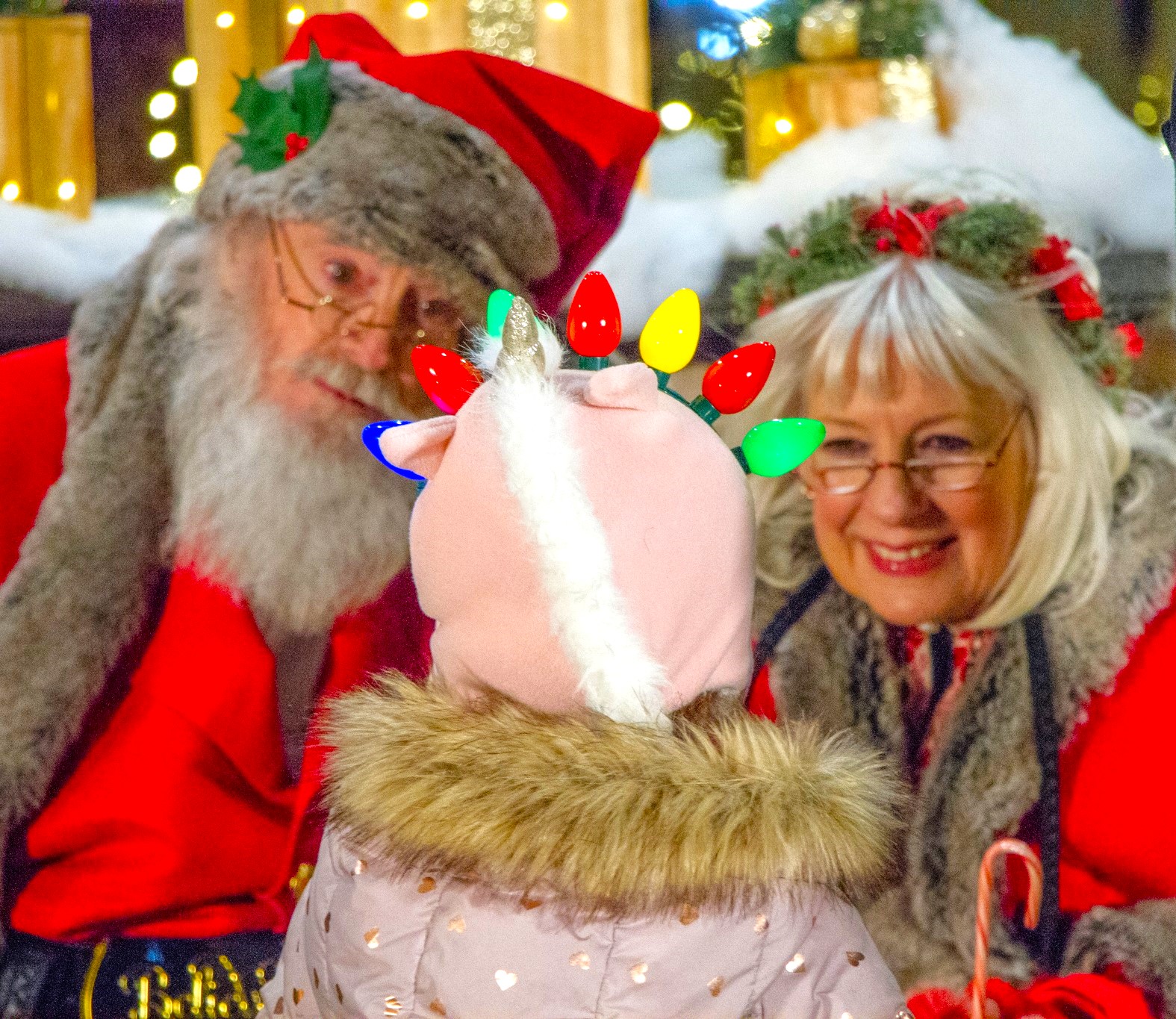 Santa and Mrs. Claus are all ears as a young visitor welcomes them to last year's Lighting of the Green.(Photo provided)