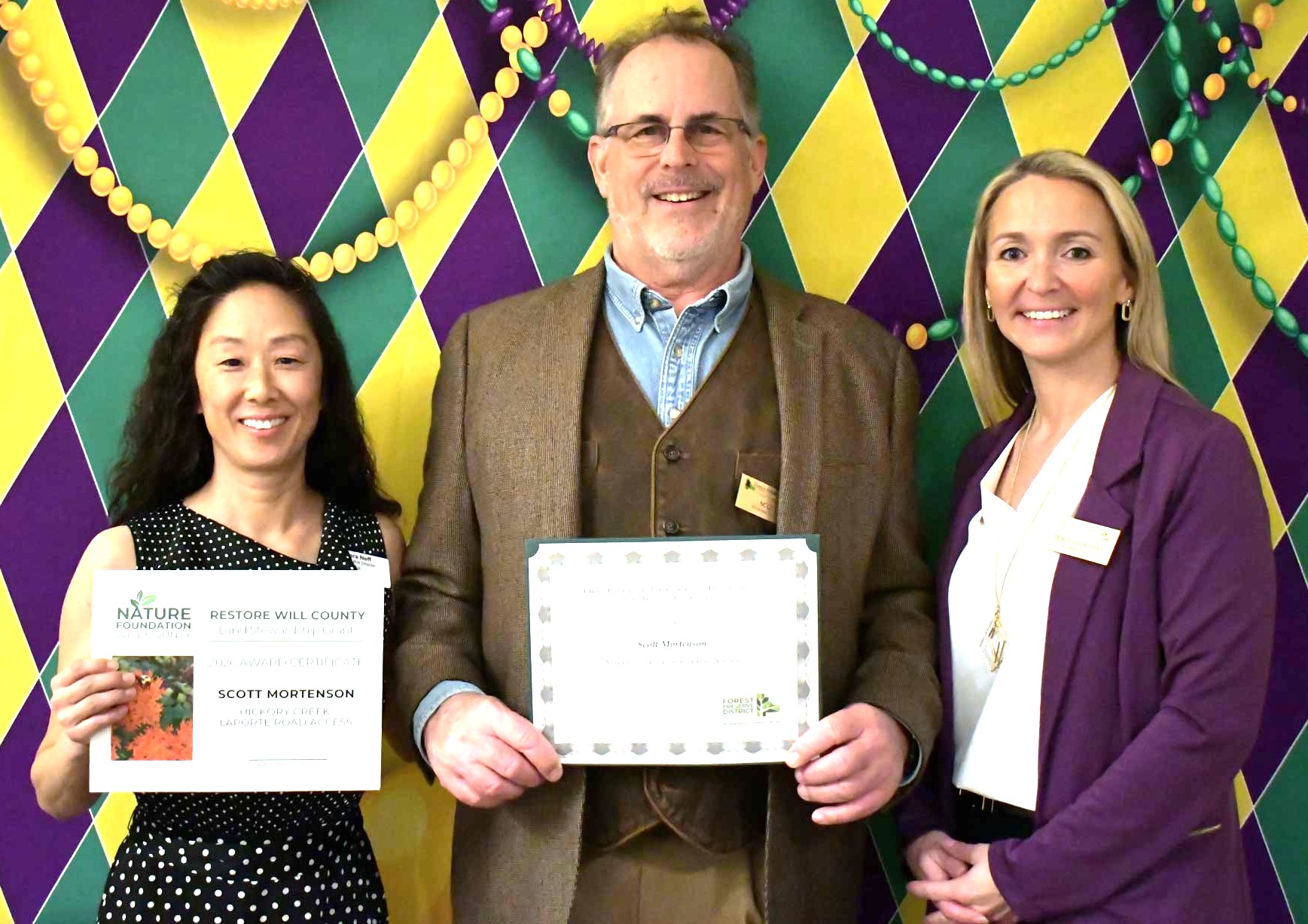 Photo cutline: Scott Mortenson, center, receives his Volunteer of the Year award from Forest Preserve Executive Director Tracy Chapman, right, and a Restore Will County stewardship grant from Tara Neff, executive director of The Nature Foundation of Will County (left). (Photo by Glenn P. Knoblock)