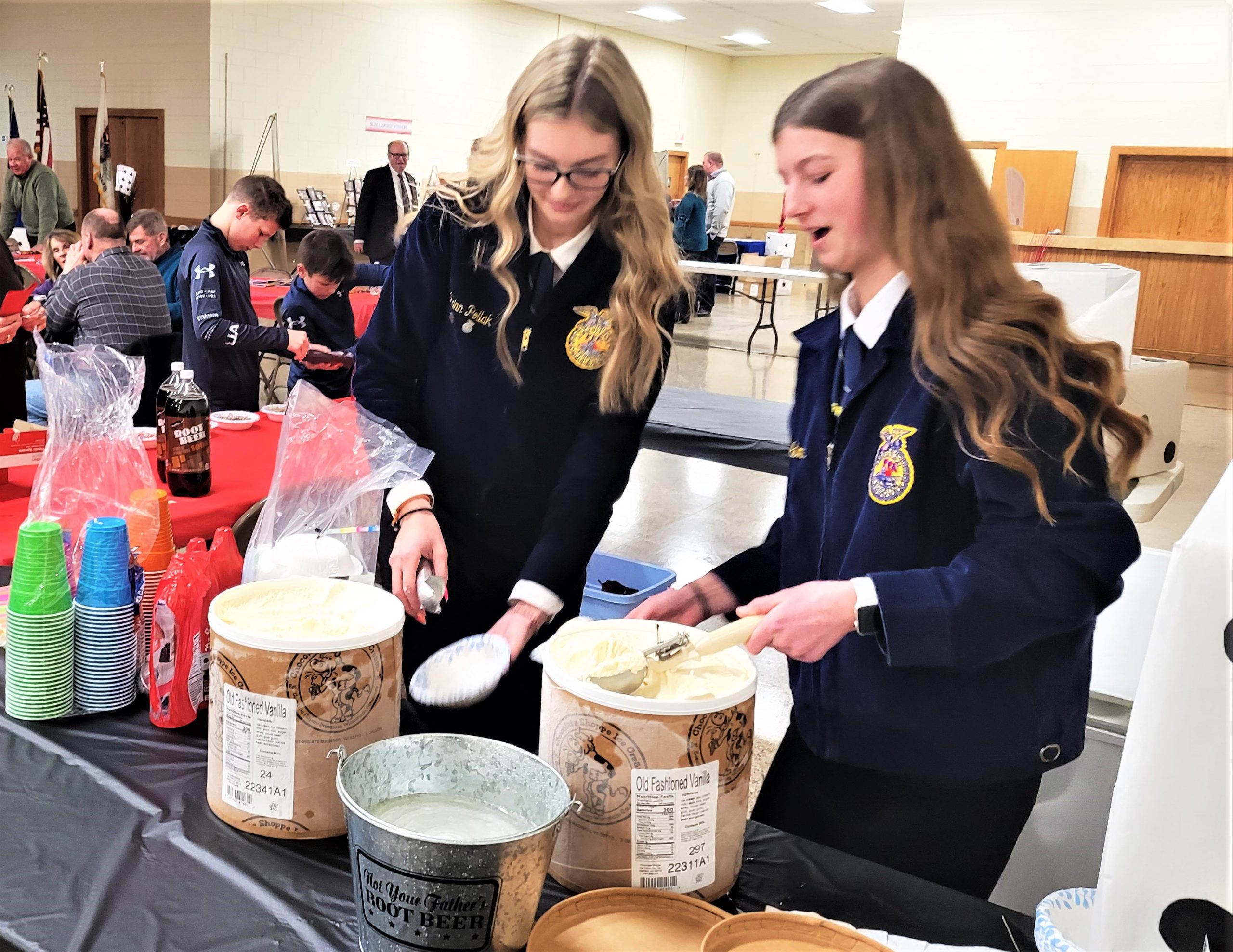 The Will County Farm Bureau held its 109th Annual Meeting Saturday, Jan. 28 at the County Fairgrounds Atrium in Peotone. Peotone Future Farmers of America members Quinn Pollak and Emma Bialko, above, had to use some extra muscle to serve during the ice cream social. Right, Mark Jones Section 10 FFA Vice President and member of the Peotone FFA, presents the U.S. Flag before the meeting. Below, John and Cora Kiefner, left, ran the 6-foot puzzle game, where participants, County Board Member Julie Berkowicz and Roger Ross help complete the puzzle.