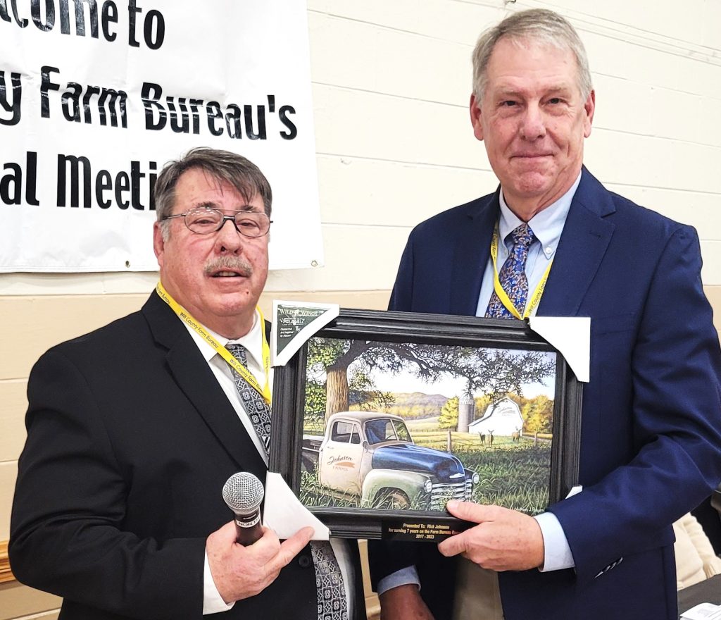 Rick Johnson stepped down off the Farm Bureau Board because of tenure and was provided the retiring board member picture with Johnson Farms on the barn and truck during the 110th annual meeting of the Will County Farm Bureau. Presenting the award was Steve Warrick Sr.