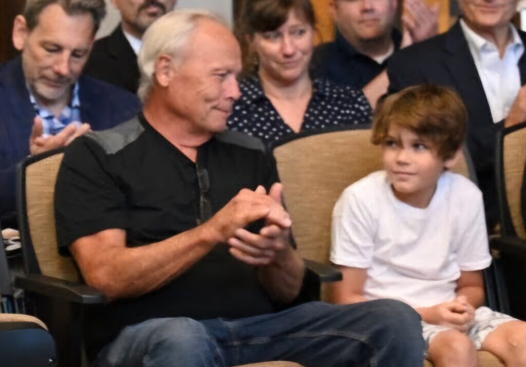 Steve Friebele joins in congratulating his grandson, Trenton Richmond, who was honored at the July 17 Elwood Village Board meeting for the 911 call that saved his grandfather’s life.(Photo by Stephanie Irvine)