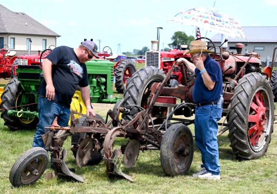 Gary Anderson and Roger Salzman look over Salzman’s 1939 Farmall, one of the many tractors on view at the 62nd annual Threshermen's Show at the Spiess Farm in Manhattan July 18-21.(Photo by Stephanie Irvine)
