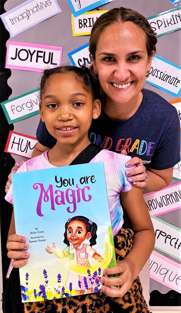 Skiilar Evans is pictured with her teacher, Kathryn. Burnham, holding her book “You Are Magic."