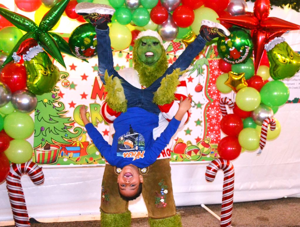 Oliver Flores of Crete gets the shakedown from the Grinch at Crete Country Christmas. (Photo by Karen Haave)
