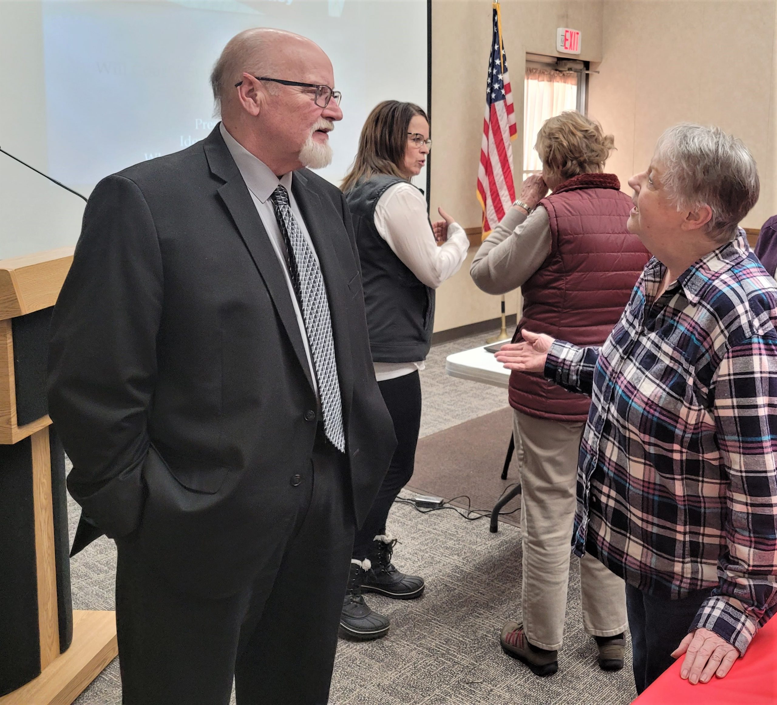 Ken Gray, foreground, and Megan Brooks, background, both of the Will County State's Attorney's Office, chat with members of the PrimeTimers Committee following a February 1 presentation on senior scans and identity theft. This was the group's first program of 2023.