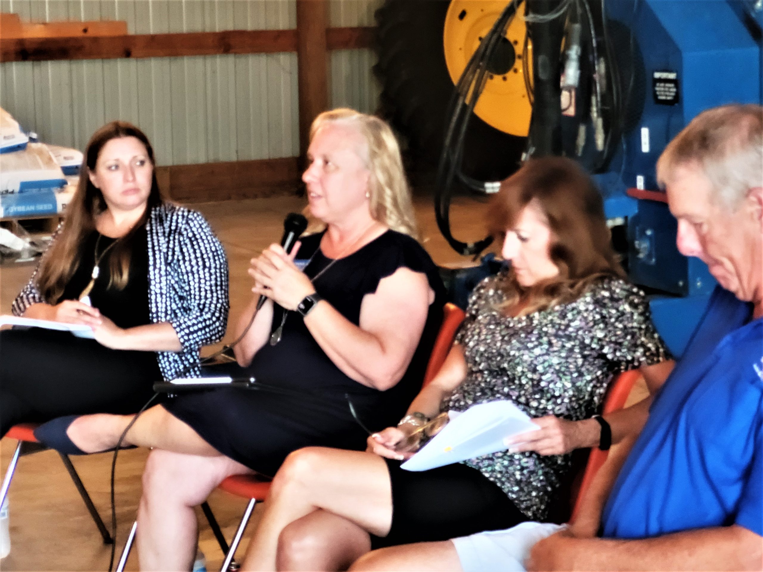 The Will County Farm Bureau sponsors Barn Meetings annually with state legislators to get their perspectives on a range of topics. At the meeting at the Dave Kestel Farm in Manhattan, Donna Wandke, above, chief of staff for Representative Janet Yang Rohr, discusses the water access bill their willingness to work with the Farm Bureau on the issue. State Senators Robin Ventura and Linda Holmes wait for their chances to answer questions.