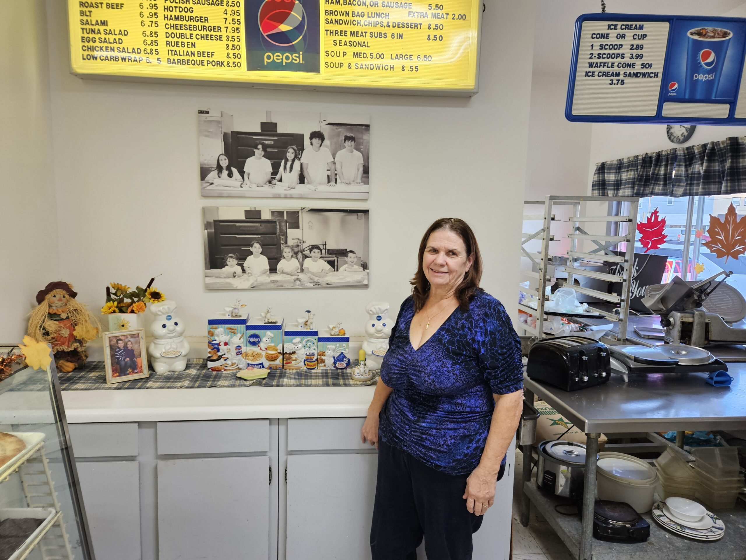 Kathy Kirby stands in front of enlarged photos of her grandchildren, one taken last year, and the other six years before. She said spending more time with them was a big factor in her decision to close Kirby's Korner Bakery next week after 35 years.