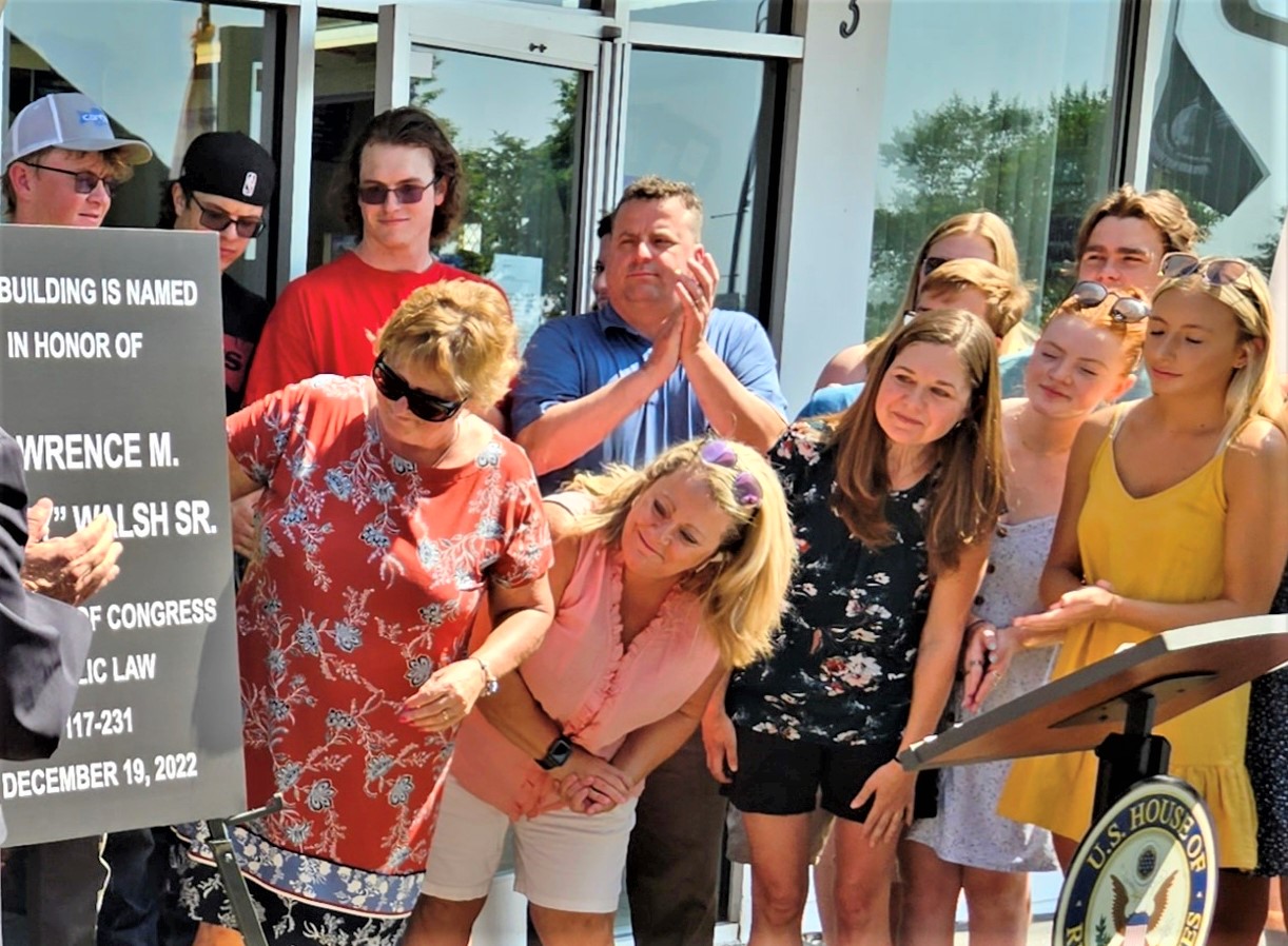 Members of Larry Walsh Sr.'s family react to the unveiling of a symbolic marker noting the dedication of the Elwood Post Office in his name, by an Act of Congress.