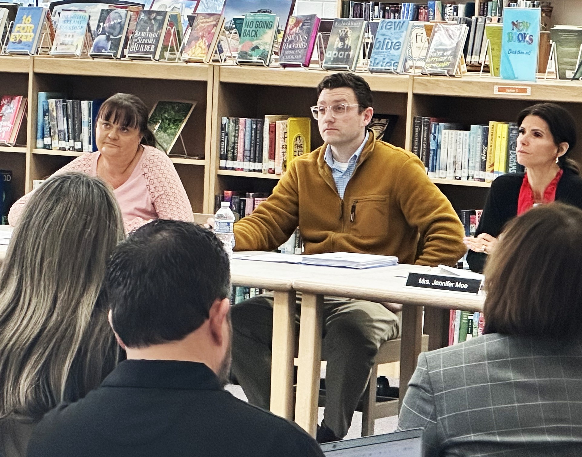 Outgoing Superintendent Brandon Owens along with Board President Dawn Love (left) and Secretary Jennifer Moe (right) listen as resident Katie Stoub addresses the board in front of a packed room.(Photo by Andrea Arens)