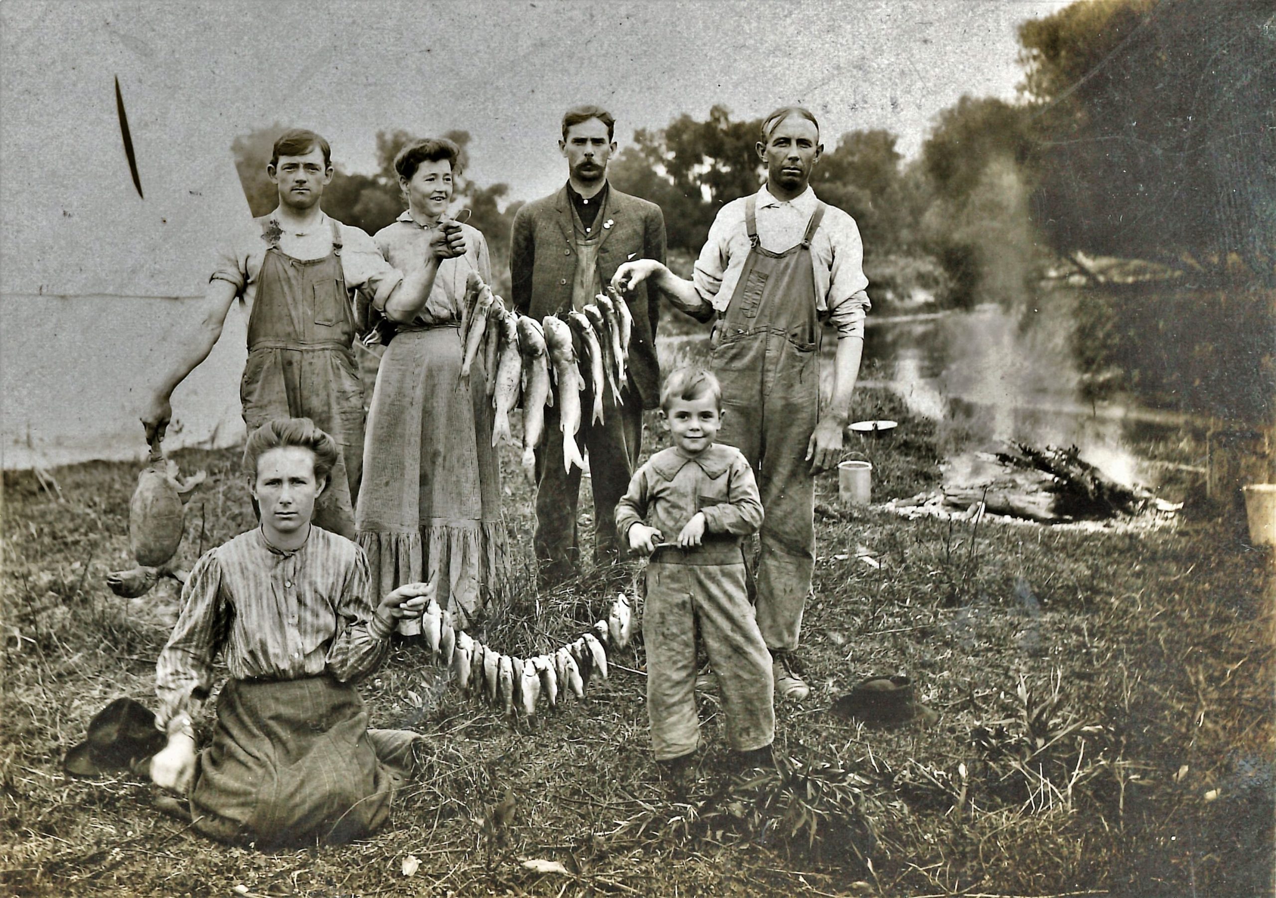 Fishing was a fun way to feed a large family back in the day, especially along the shores of the Des Plaines River. This family had a mess of fish, a turtle and a campfire ready to go for dinner.