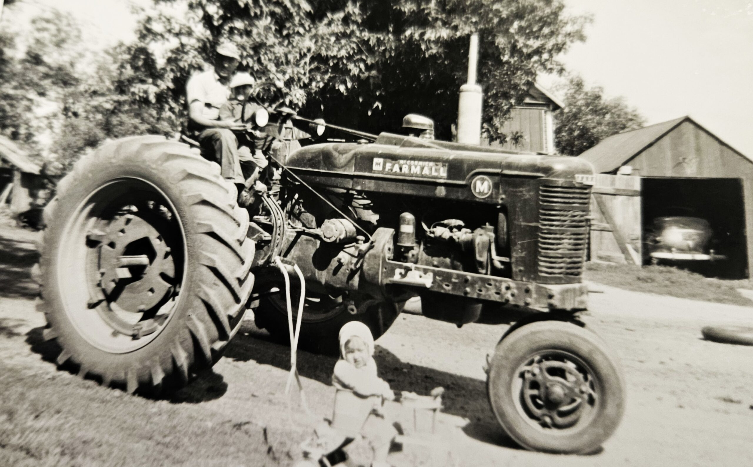 We got a bunch of old pictures dropped off at the office, which was nice, because we're running low. This one shows George Herbst running the tractor on his Green Garden farm in 1947. Supervising are his son Tom and daughter Kathy.