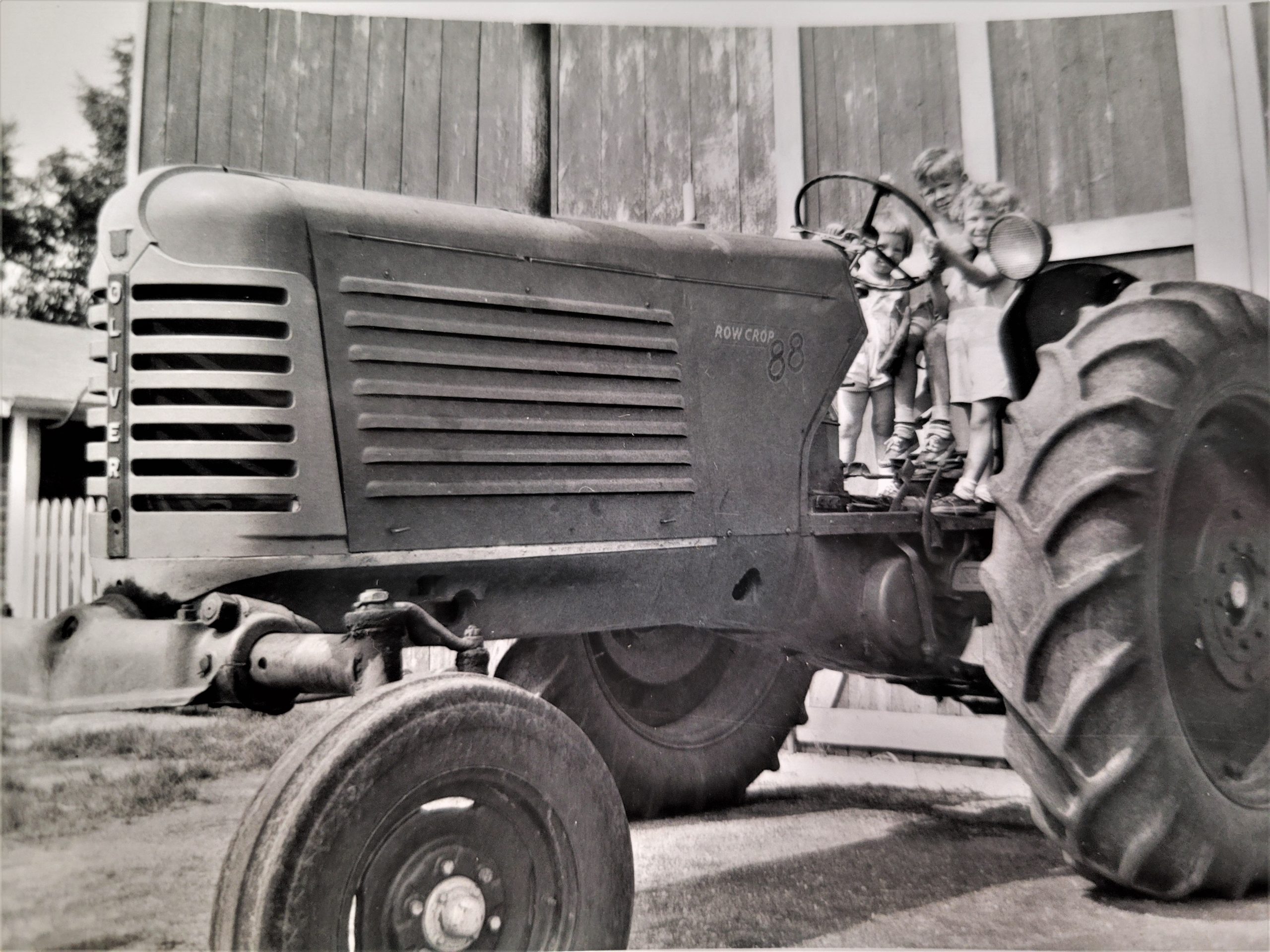 You're never too young to start on the tractor. On the old Oliver tractor in 1955 are Denee Wilhelmi, Sherry and Marleen Wilhelmi on the Eugene Wilhelmi farm in Elwood.