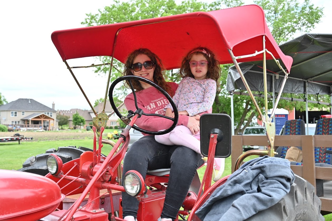 Kally Marsee and her daughter, Mariella, check out a tractor during the Vintage Tractor Drive’s lunch stop. (Photos by Stephanie Irvine)